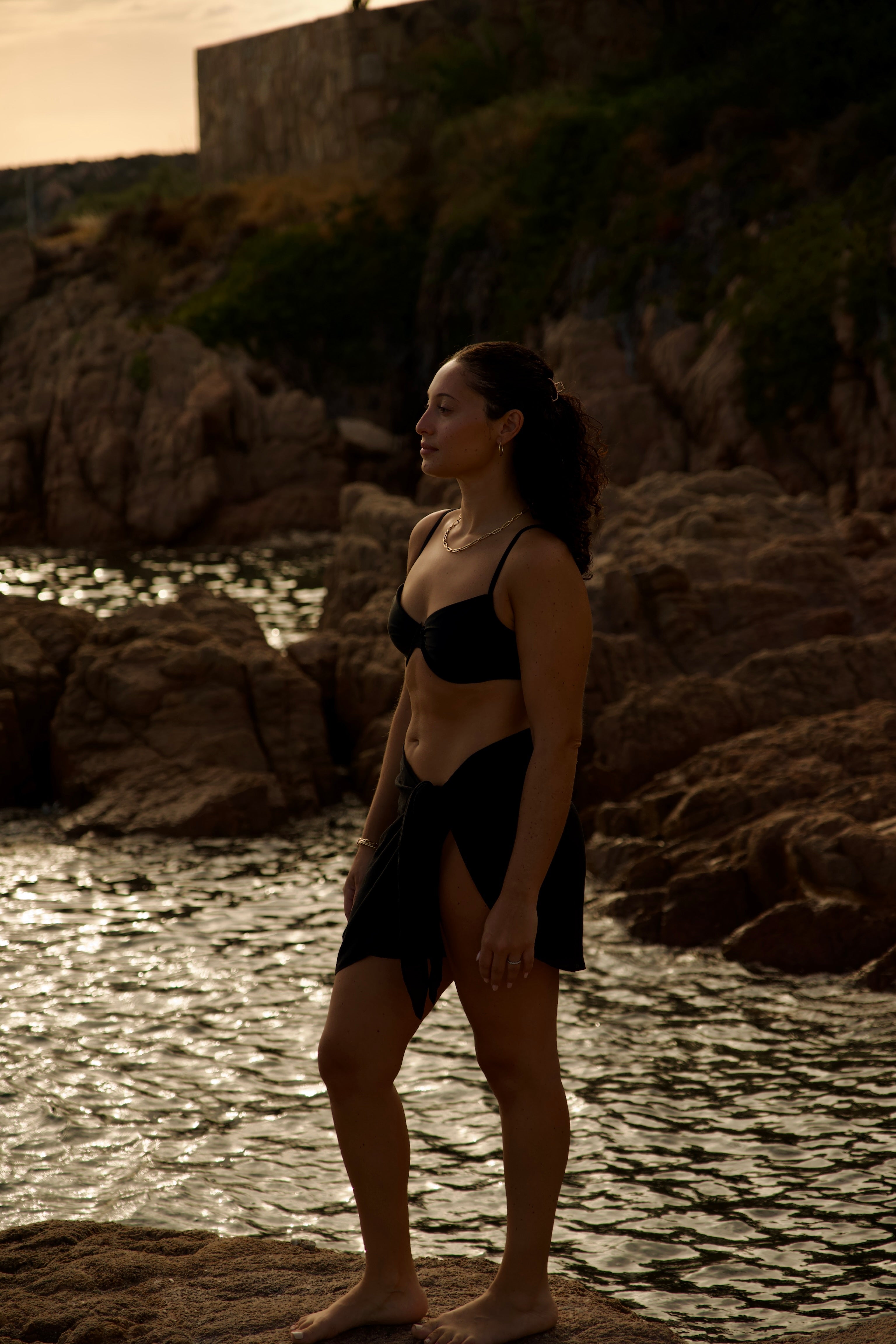 Confident woman posing in Occeanwear resort wear by the ocean”