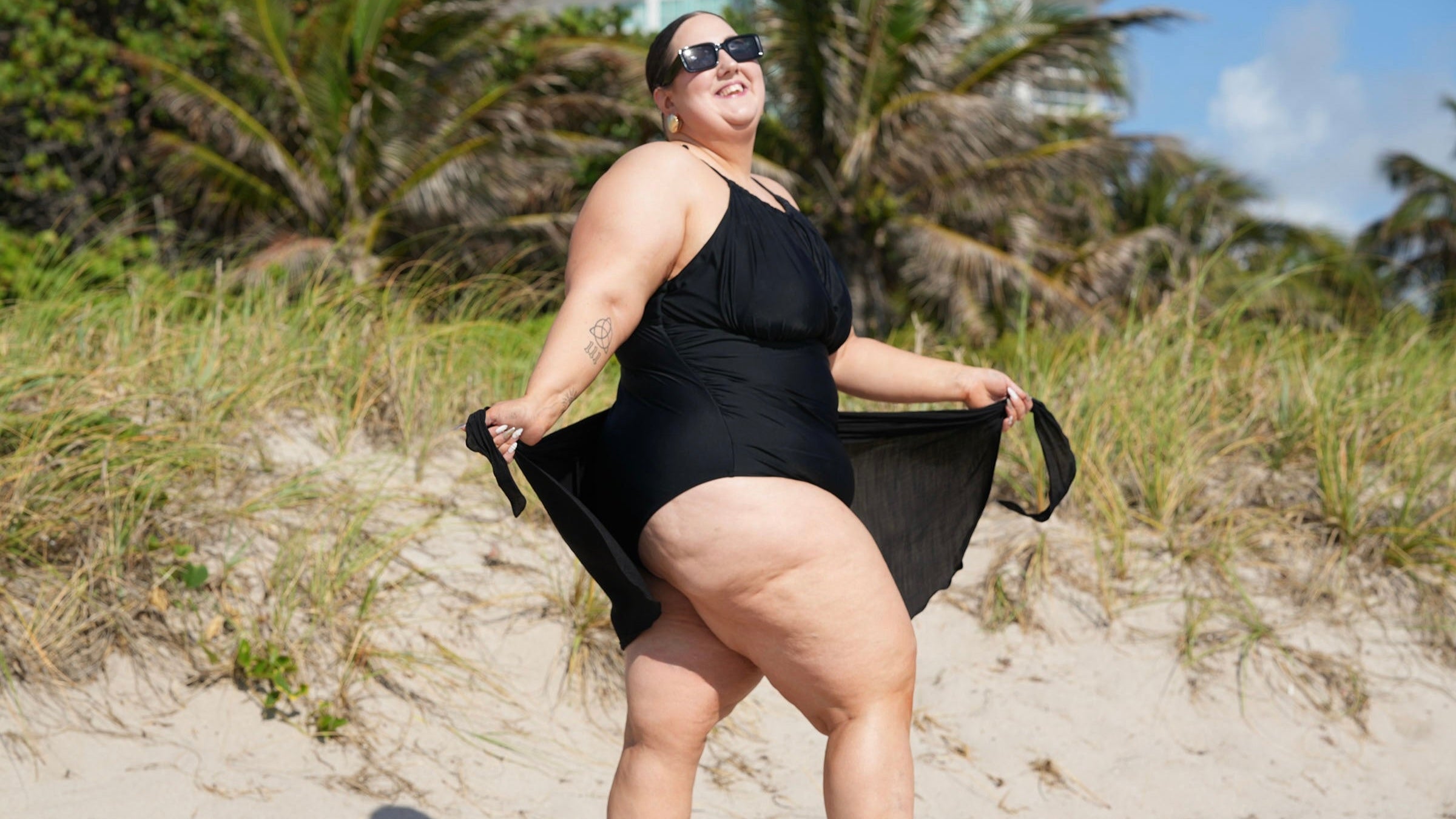 Smiling model in elegant swimwear, celebrating self-confidence and body positivity